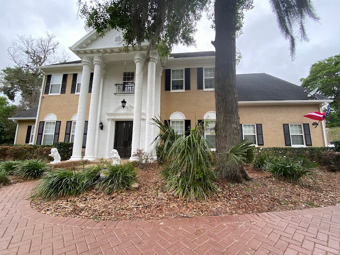 Two-story Florida home with white columns and painted stucco