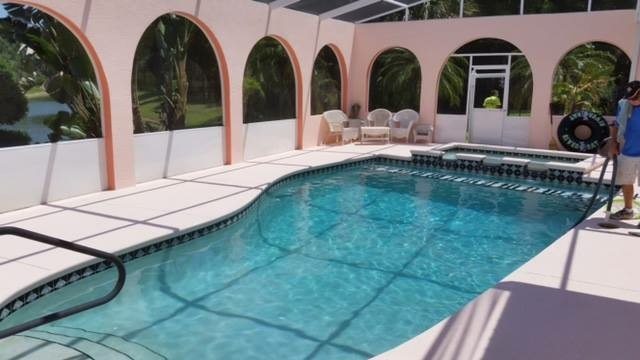 Fresh light pool deck coating inside an arched Florida pool enclosure